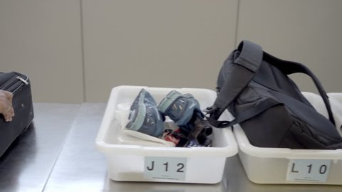 NEW YORK - JULY 1, 2016: trays with shoes and backpacks in security check at JFK airport in 4K in NY. Security checks are a typical experience in American airports.