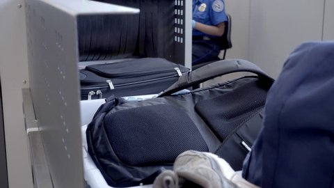 NEW YORK - JULY 1, 2016: baggage security check at JFK airport in 4K in NY. Conveyors transport personal items in trays across security points in American airports.