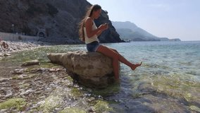 woman surfing in smartphone on beach near sea