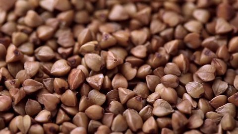 Rotating raw buckwheat. Spinning closeup dry uncooked seeds. 1280x720. Slow Motion