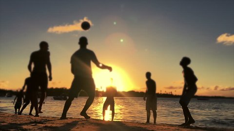 Silhouettes of Brazilians playing altinho beach football at sunset on a tropical beach in Bahia, Nordeste, Brazil