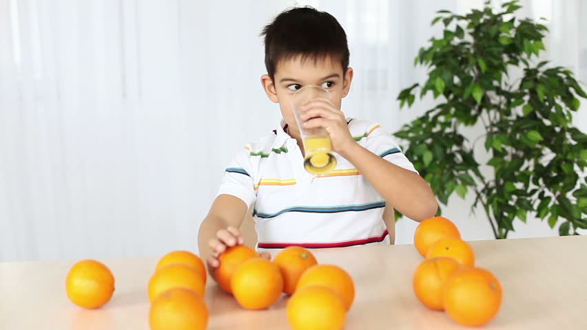 Boy drinking orange juice and licked