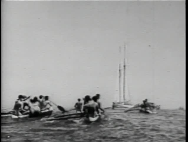 Rear view natives in canoes paddling towards boat at sea