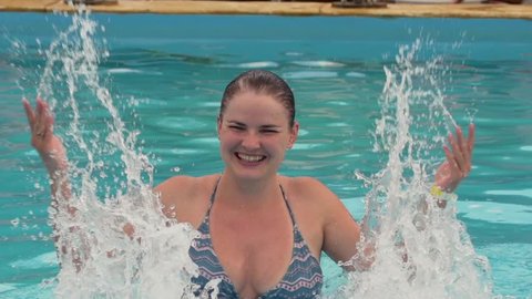 happy girl ,woman splashing in swimming pool Slow Motion