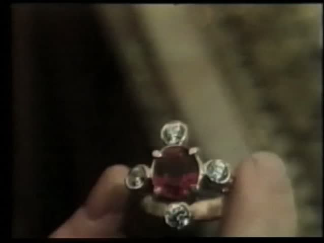 Close-up of hand holding ruby ring