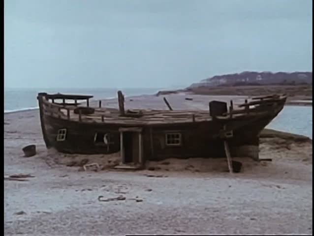 Wide shot of abandoned boat on land