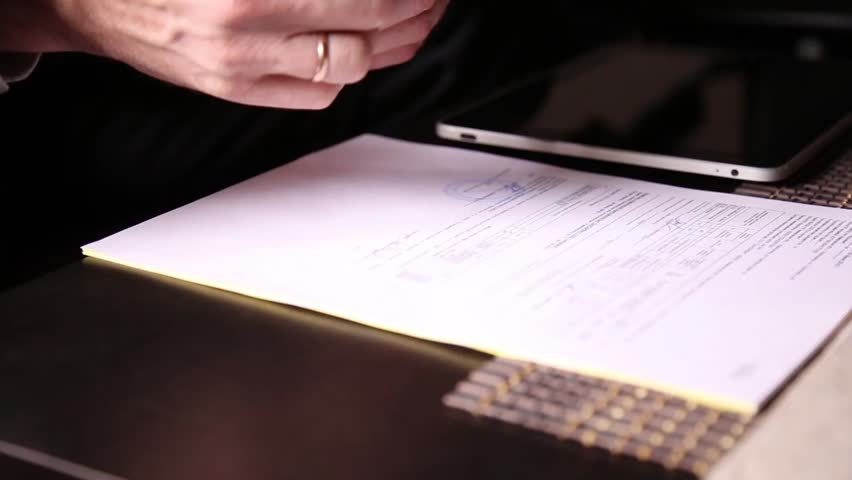 Businessman sitting office desk signs a bill comparing them, with the pc tablet. close-up hands of a man and a fountain pen Royalty-Free Stock Footage #18421267