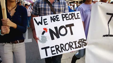 "We Are People Not Terrorists" Rally Sign. A white picket sign that reads, "We Are People, Not Terrorists" is held up during an immigration rally in downtown Los Angeles on September 22, 2013.
