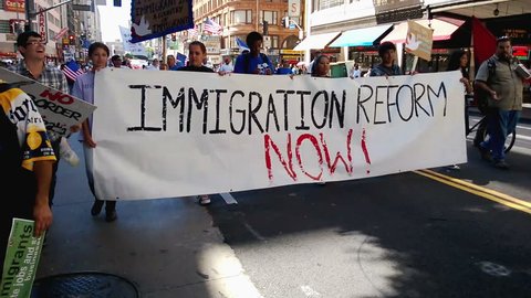 Immigration Reform Banner. A large white picket banner that reads, "Immigration Reform Now!" is held up and carried by multiple people during an immigration rally in Los Angeles on September 22, 2013.