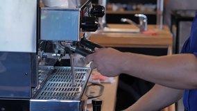 Barista preparing cup of coffee for customer in coffee shop.