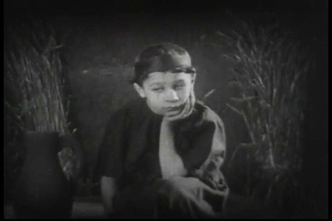 A biblical scene in the 1920s, reenacted as a dream, about the Widow of Zarephath\xEAs anguish and her son\xEAs uneasiness about their scarcity of food. (1920s)