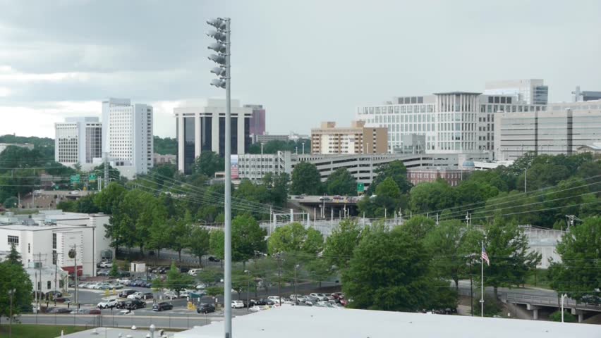 Charlotte city skyline with baseball light, car traffic, and American flag