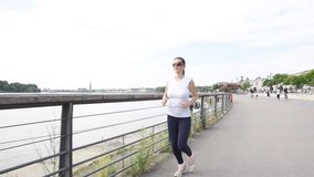 Runner woman exercising in town, riverside