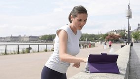 Fitness girl in town exercising with virtual coach