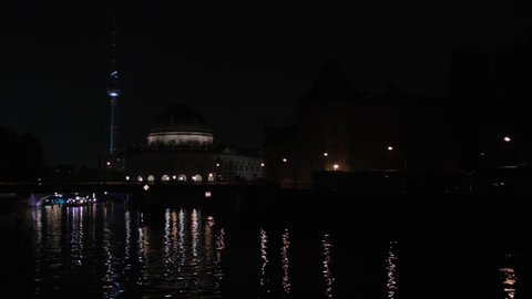 BERLIN, OCTOBER 2015 - Timelapse Of Berlin Tv Tower And Bode Museum With Lightshow And Two Party Boats Passing Under Bridge Left To Right With Traffic In Background.