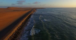 Aerial and bird perspective view from drone of Namibian Atlantic coastline, sand dunes, sunny horizon and landscape with ocean background south of Swakopmund off highway towards Walvis Bay in Namibia