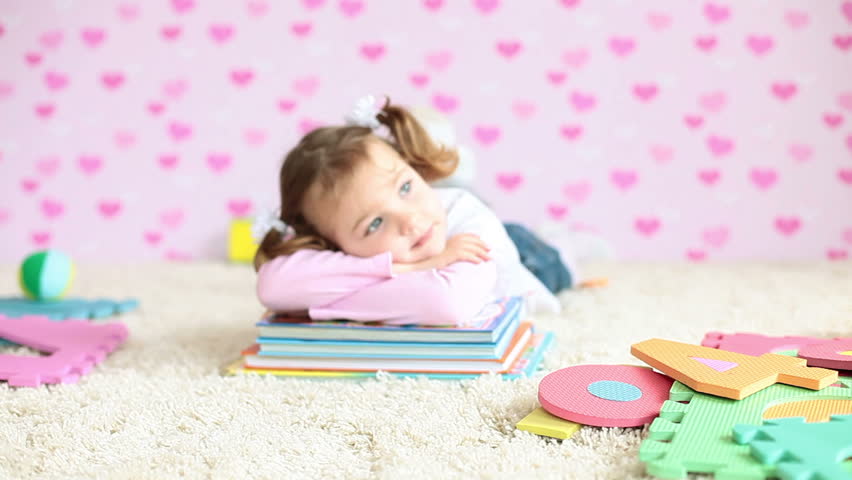 Preschooler with books lying on the floor