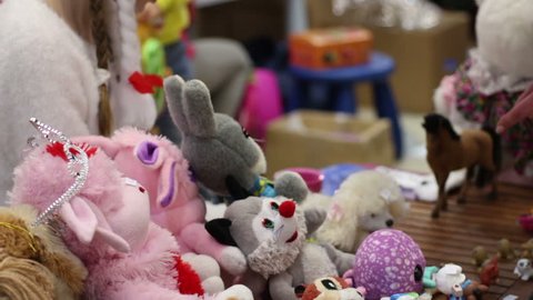 People selling soft toys at charity garage sale, raising funds to help children