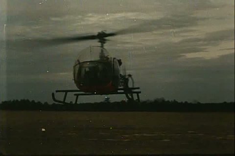 Helicopters of different kinds hover over a landing spot showing their abilities for observation in the 1970s. (1970s)