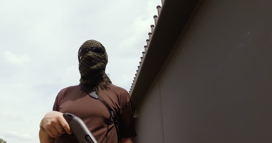 The man with the gun is on the industrial zone