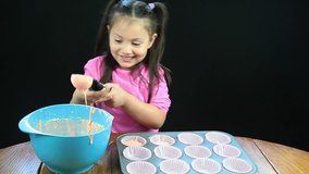 Young girl filling muffin tins at kitchen table - HD - 1920x1080