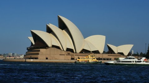 SYDNEY, NEW SOUTH WALES, AUSTRALIA - OCTOBER 4, 2014: Traditional and modern ferries pass each other in front of the Sydney Opera House.