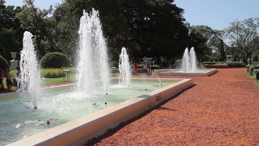 Two fountains at a walkway at El Rosedal, a nice rose garden and public park of Buenos Aires. Wide-angle view. A small part at the left edge where 3 kids play has been blurred (Argentina, Jan 2012).