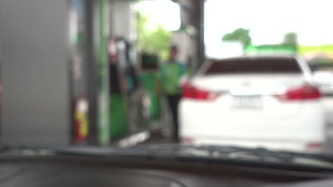 Woman refueling car at gas station pump