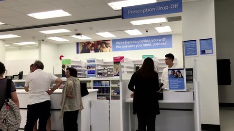 Coquitlam, BC, Canada - July 27, 2016 : People line up for picking up their prescription medicine inside Walmart pharmacy