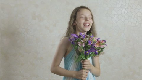 Beautiful girl with a bouquet of flowers laughing.