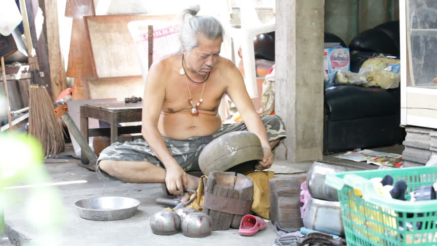 BANGKOK - NOVEMBER 12: A man shapes an alms bowl in Bangkok, Thailand on