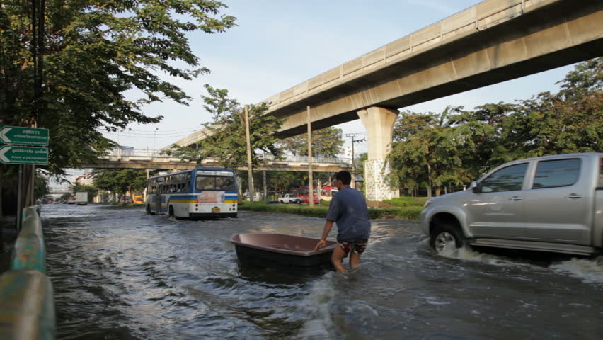 BANGKOK - NOVEMBER 7: People drive on the flooded streets of Bangkok on November