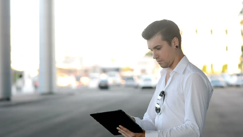 Businessman working on tablet computer in the city