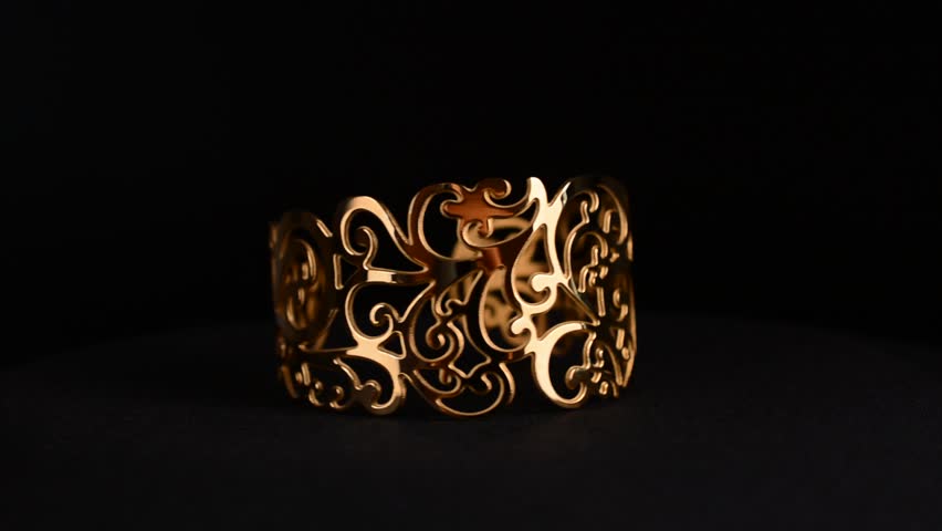 Vintage golden bracelet rotating on black background