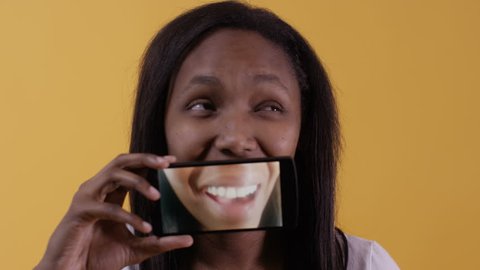 Woman uses cell phone screen for fun mouth video