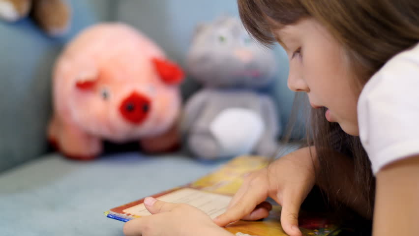 little girl reading a book for their toys