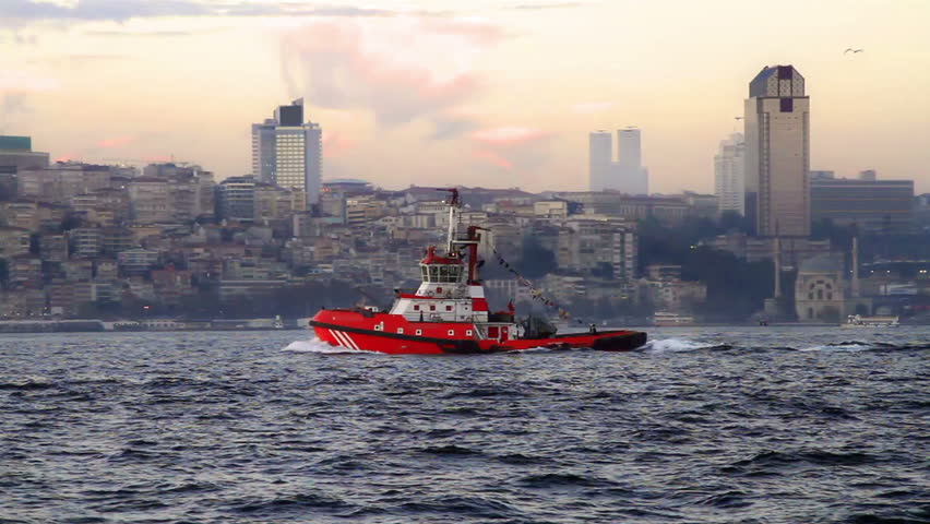 Red tug boat sails in Bosporus Sea 