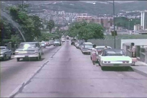 Downtown Caracas in 1973, Venezuela, museums, and city parks, with a motorist\xEAs POV driving to another section of the city, on a two lane highway along the coast. (1970s)
