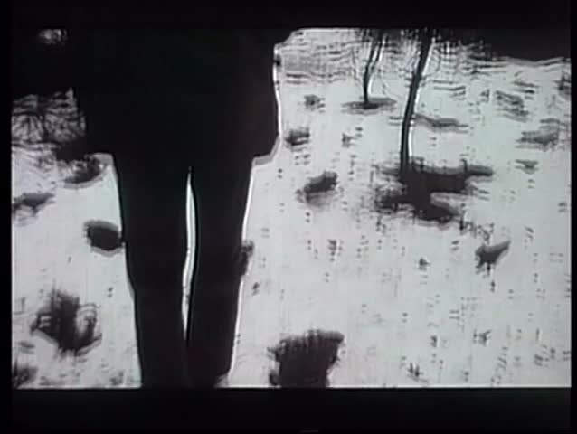 Rear view of man tracking trail of big footprints in snow