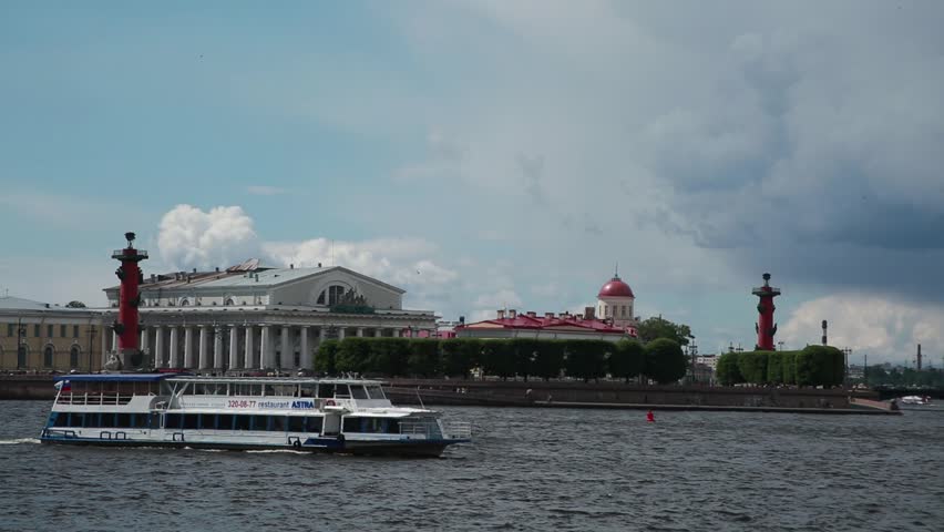 St. Petersburg. Boat with tourists floats on the river Neva, on the background of the Stock Exchange building and the Rostral Columns
