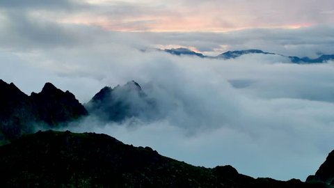 timelapse of sunset above the clouds with silhouettes of mountain tops
