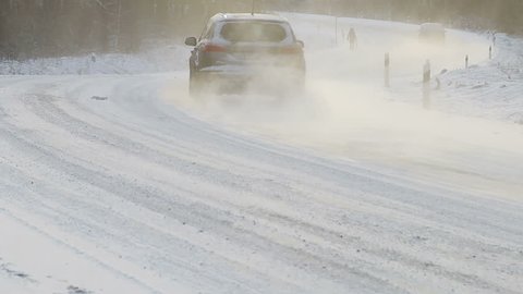cars move along the snow-covered road in the snow