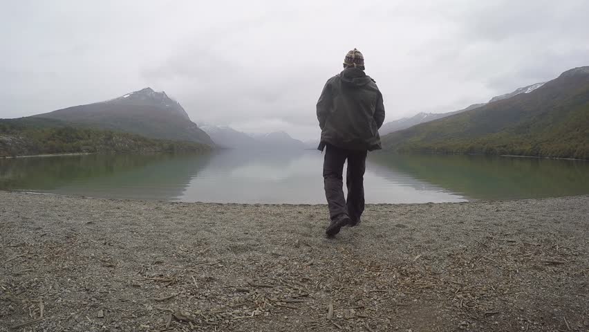 the Young Man Slowly Walks to the Lake and Admiring the Picturesque Landscape. Wild Living Nature