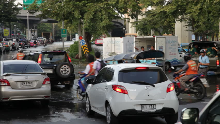 BANGKOK - NOVEMBER 7: People drive on the flooded streets of Bangkok on November