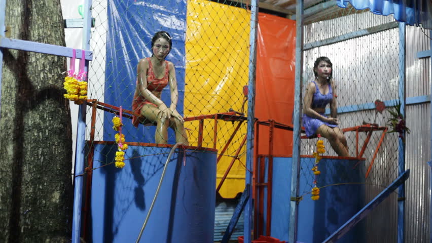 BANGKOK - NOVEMBER 7 : Two Thai girls sit over water tanks for a game in a