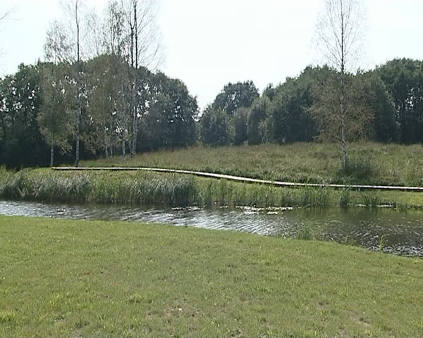 Resting Place in Nature. River, wooden log house and wooden bridge. 