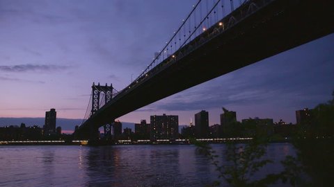 Manhatten bridge with the distinctive New York skyline in background at sunset, New York , United States