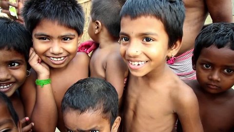 Village children in India smile, laugh and fool around in front of the camera, close up, narrow depth of field