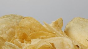 Thin salted crisps appetizer food background slow tilt 4K 3840X2160 UltraHD footage - Potato chips sliced and fried in a bowl popular snack 2160p 30fps UHD tilting  video