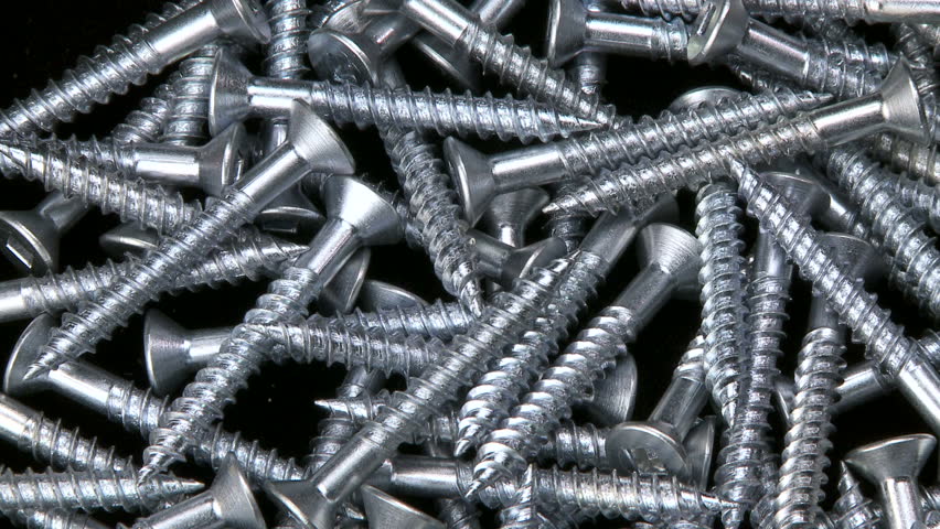 Close up clockwise rotation on a pile of hardware screws